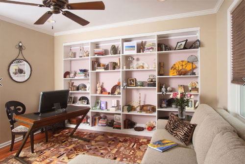 Stylish home office with built-in bookshelves and cozy seating area.