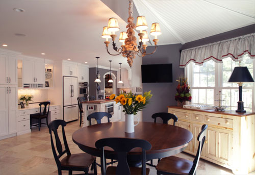 Modern farmhouse kitchen with cozy dining area and elegant lighting.