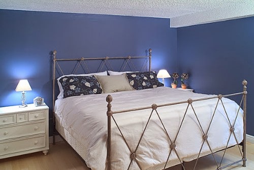 A bedroom with coastal-inspired colors and materials, such as blue walls