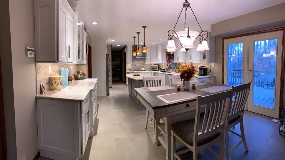 Spacious modern kitchen with white cabinets, island, and dining area.