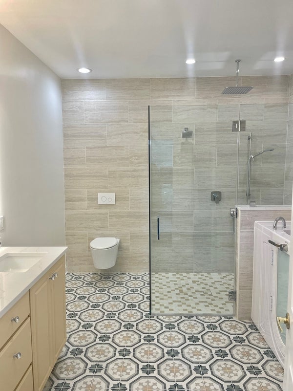 Luxurious bathroom with walk-in shower, patterned tiles, and modern fixtures.